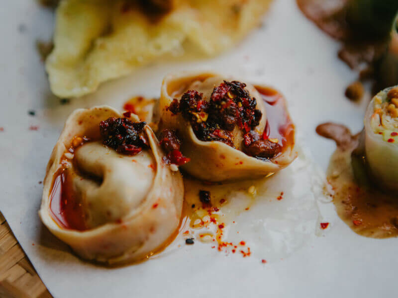 Handmade dumplings swimming in chilli oil