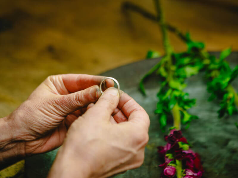 Hands holding an elegant handmade silver ring