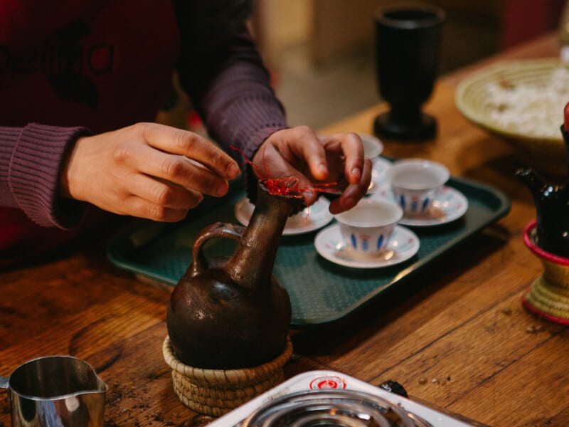 A person showing how to use a jebena