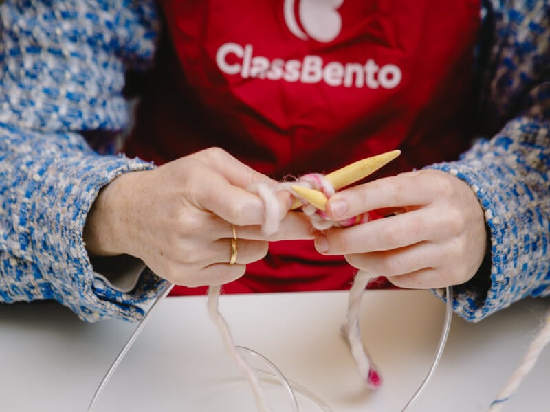 Hands holding knitting needles and yarn