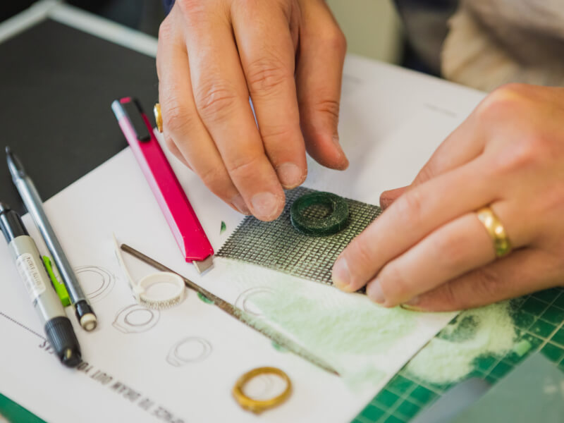 Hands depicted in the process of making a ring at a romantic ring making class