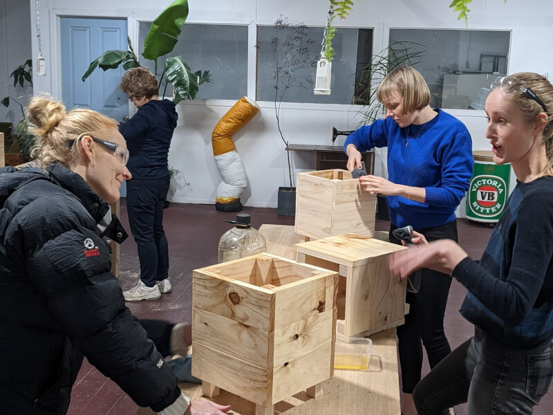 Three women making wooden planters at handy women workshop in Melbourne