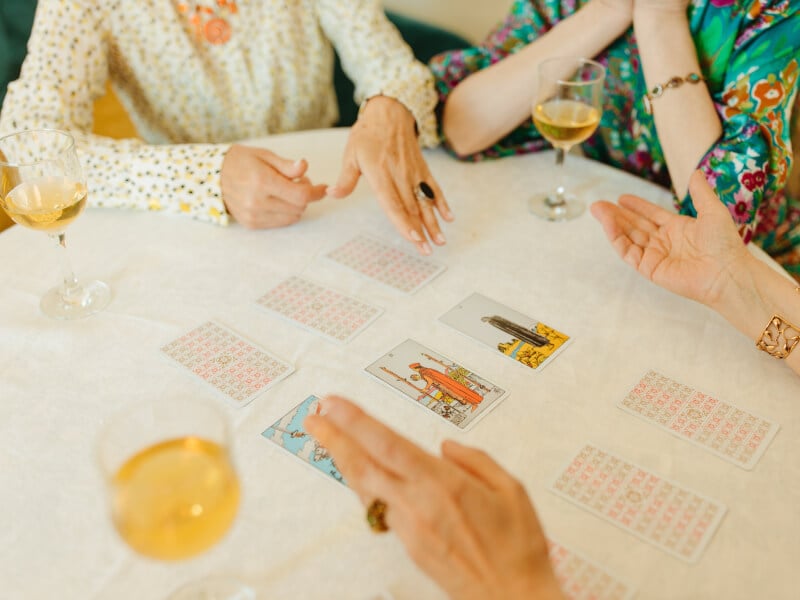Women analysing tarot cards around a table for a hens party