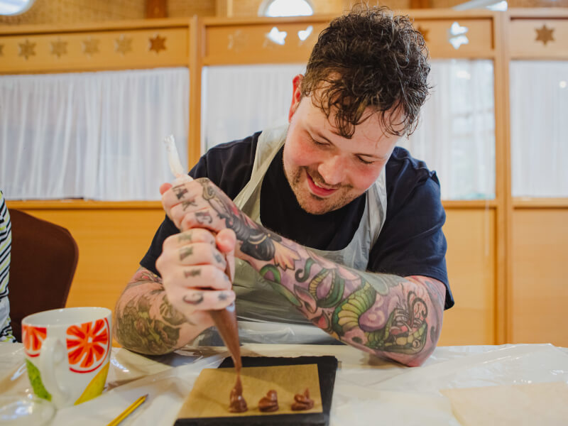 A man makes truffles at the chocolate workshop he was gifted
