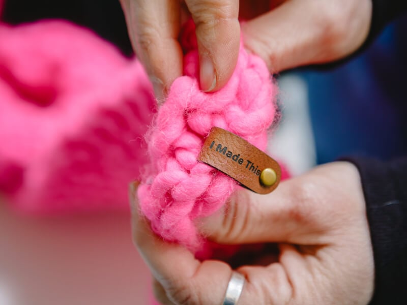 Hands holding a ball of yarn with label saying 'I made this'