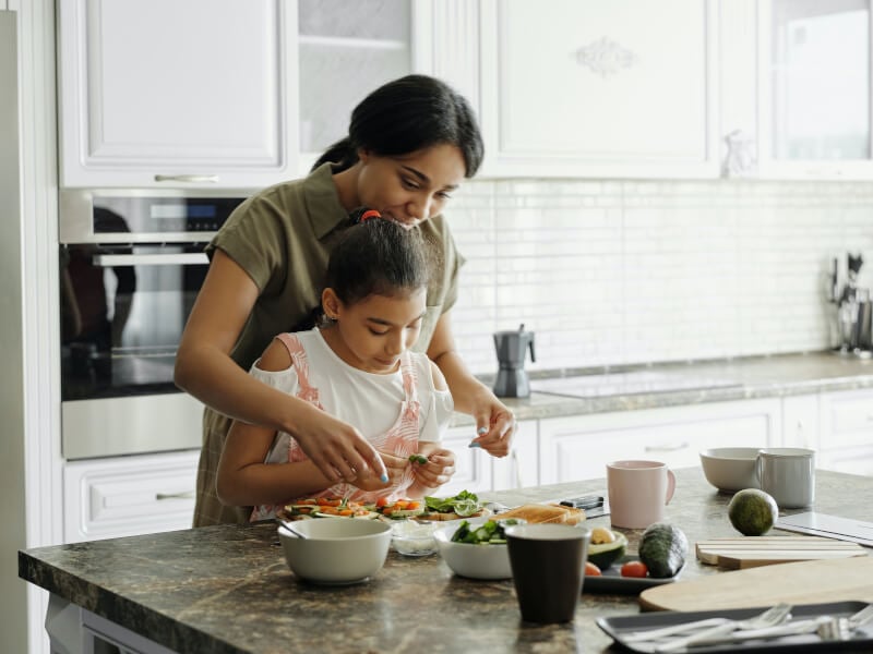 mother and daughter cooking at home
