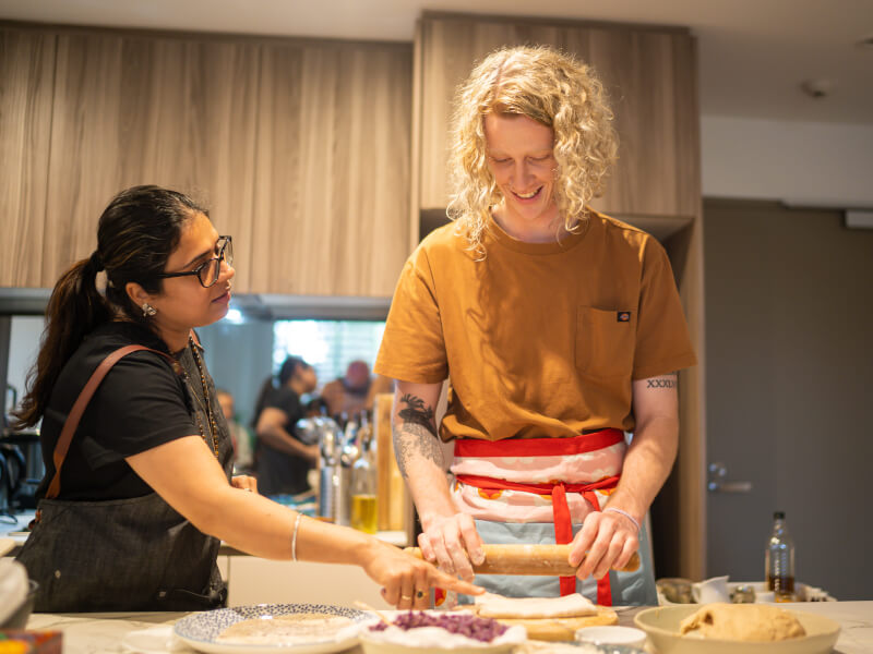 Teacher helping student make Indian dishes
