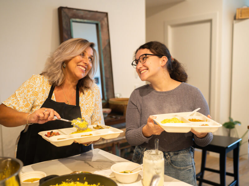 Two women enjoying an Indian cooking class for a birthday celebration