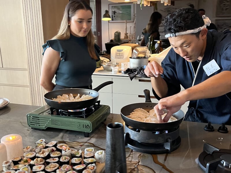 Japanese chef teaching student to cook gyoza and sushi
