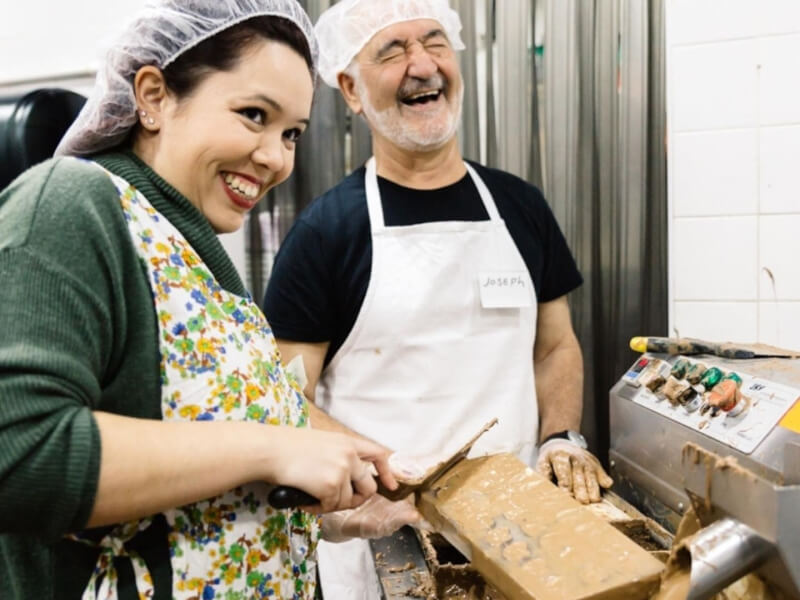 Joseph laughing with a messy chocolate student