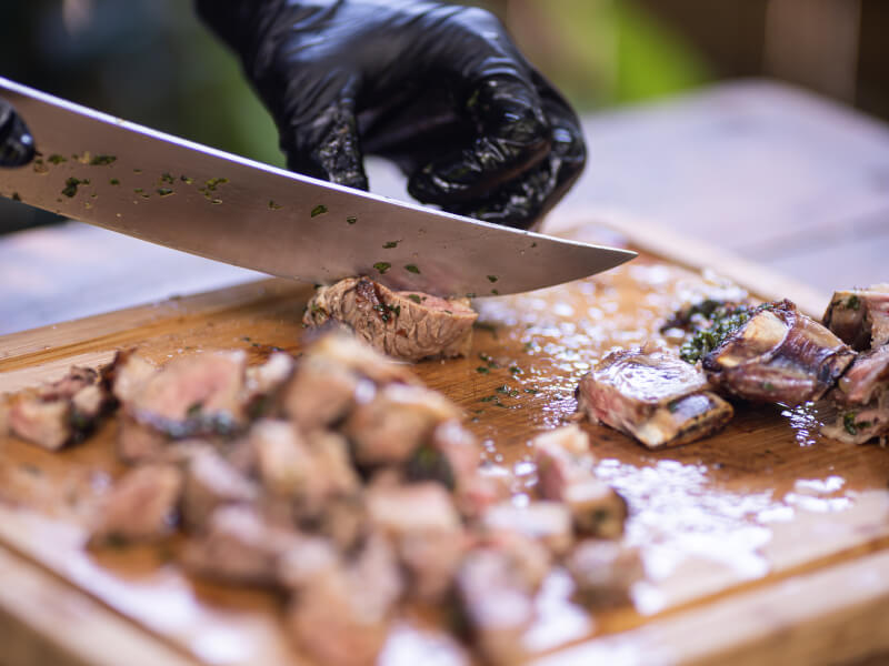 A man cuts BBQ'd meat for his birthday experience