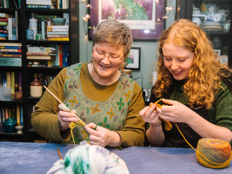 A mother and daughter knitting together