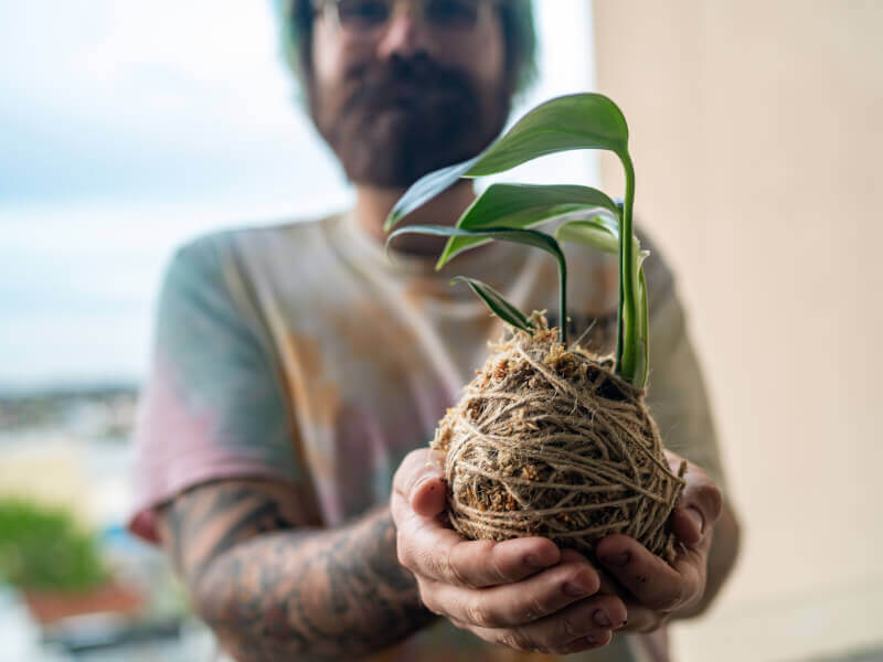 A man holds a kokedama he made on an anniversary experience gift