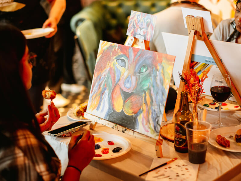 Woman painting lion at paint and sip class Melbourne