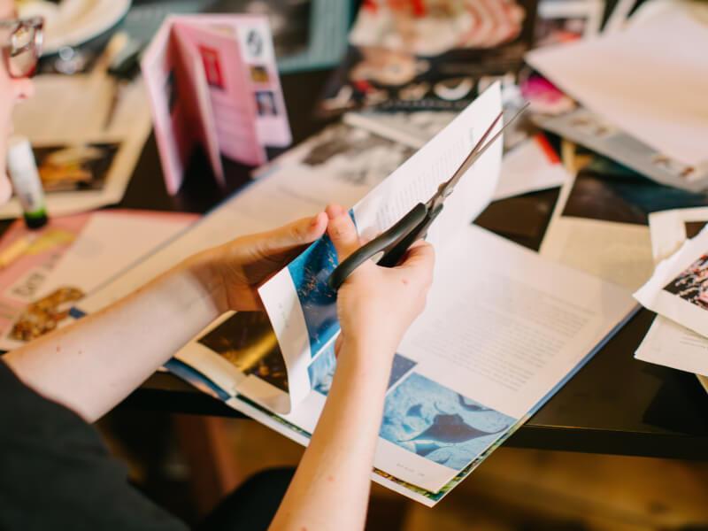 A woman cuts magazines for collage making