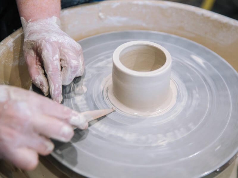 Trimming clay on a pottery wheel