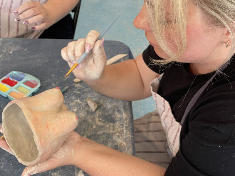 A woman making a boob mug at a ceramics class