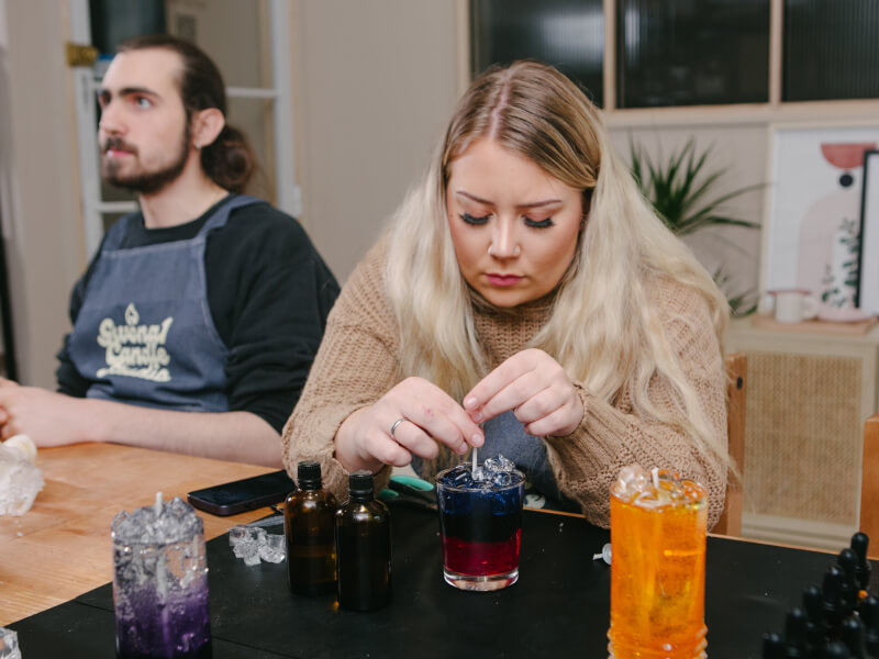 Woman making cocktail-shaped candles at the candle making class she was gifted