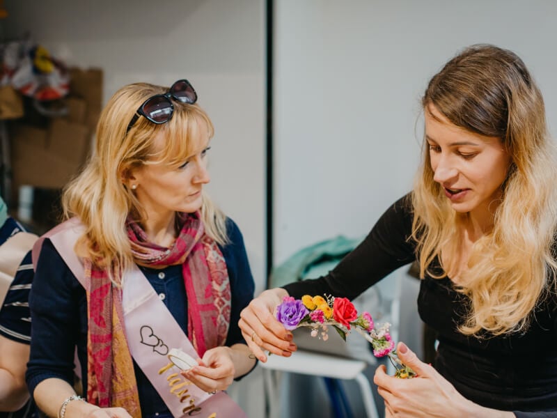 Two friends making flower crowns at a hens party