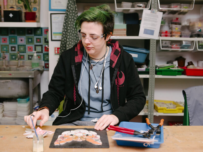 A person mindfully making a mosaic cat