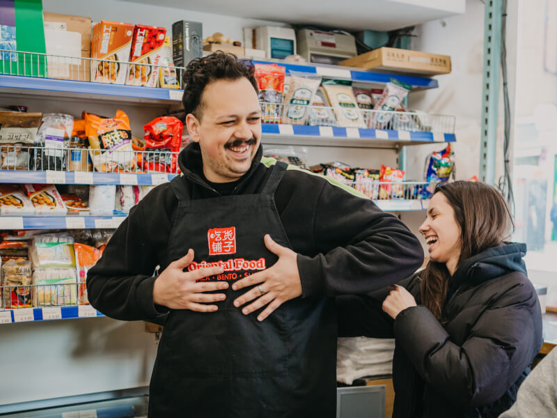 A man and woman laughing together at a cooking class