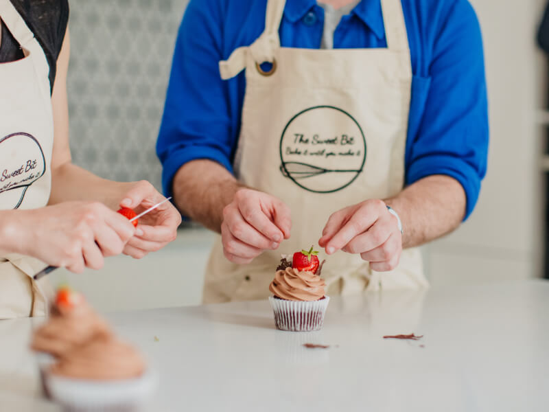 man and woman at cupcake decorating class