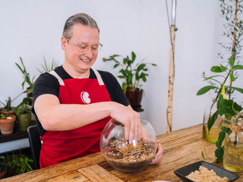 Man smiling white making a terrarium
