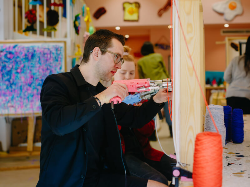 A man focused on a fun tufting project
