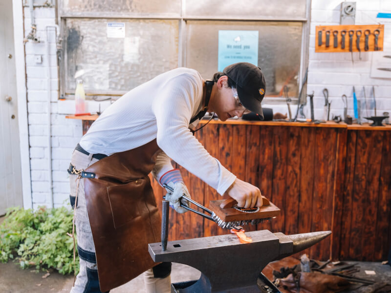 A man makes a knife at a knife making class