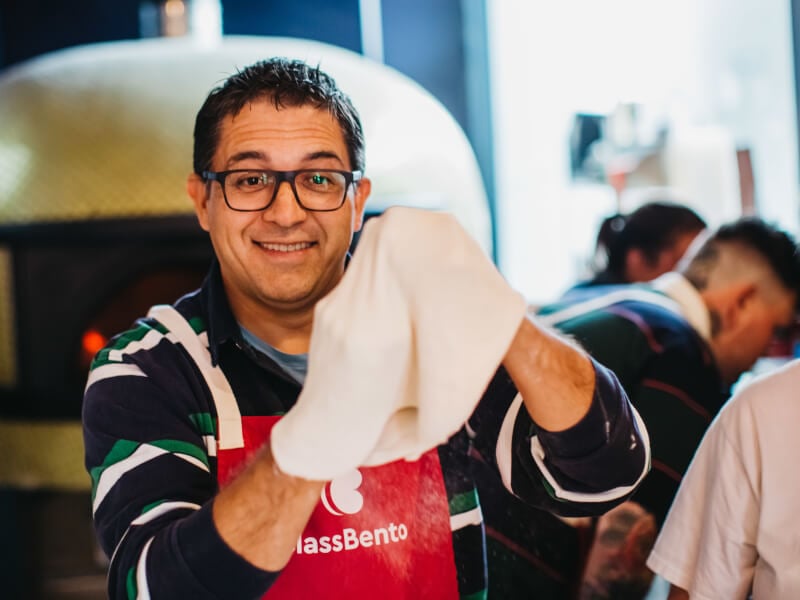A happy man makes pizza dough at a cooking class