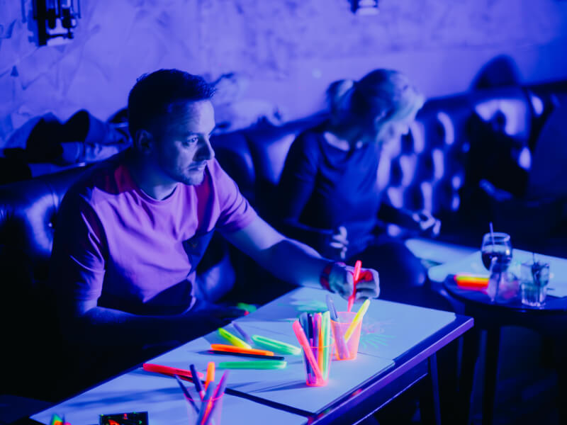 A man enjoys a neon drawing class he was gifted