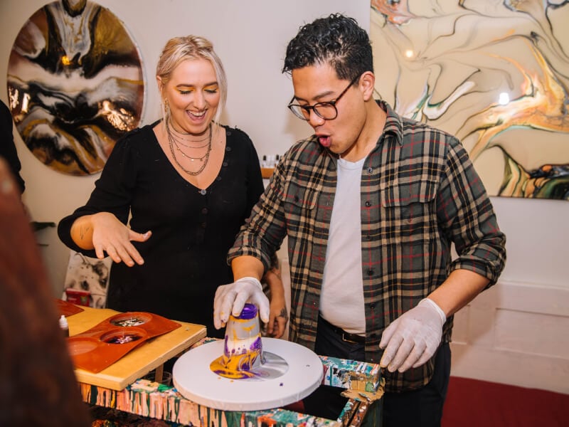 A couple getting messy at a fluid art class