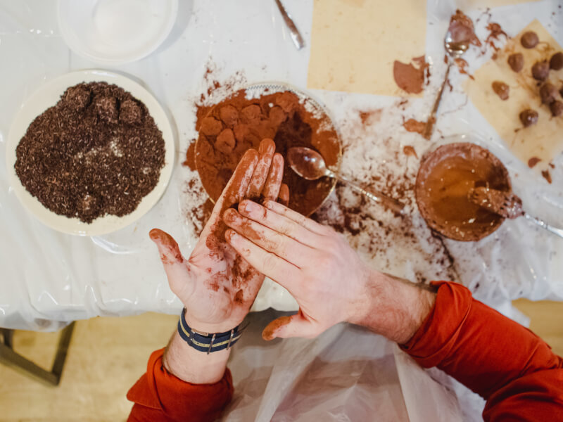 Messy hands making chocolate truffles