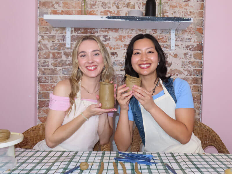 Two friends make mugs at a pottery class in Perth