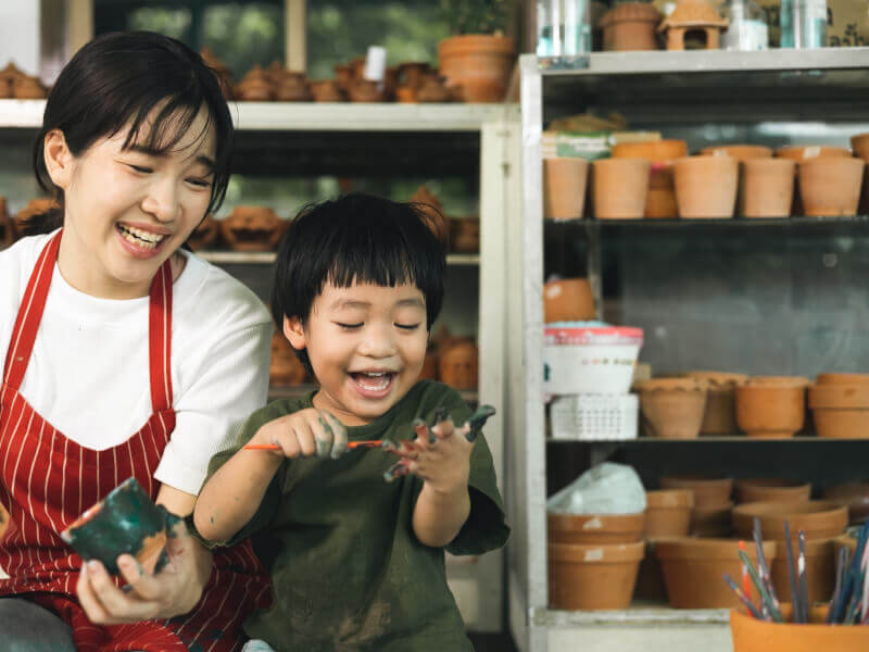 A mother and toddler laughing at a pottery class