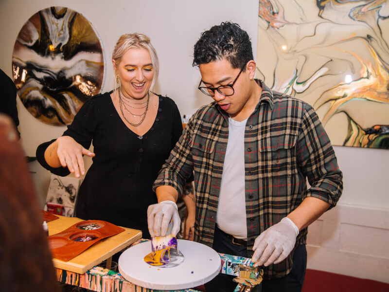 A couple get messy at a resin art class