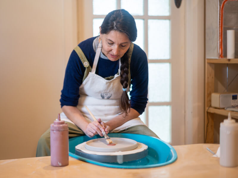 Woman painting pottery