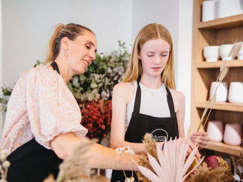 A mother daughter duo arrange flowers for Mother's Day