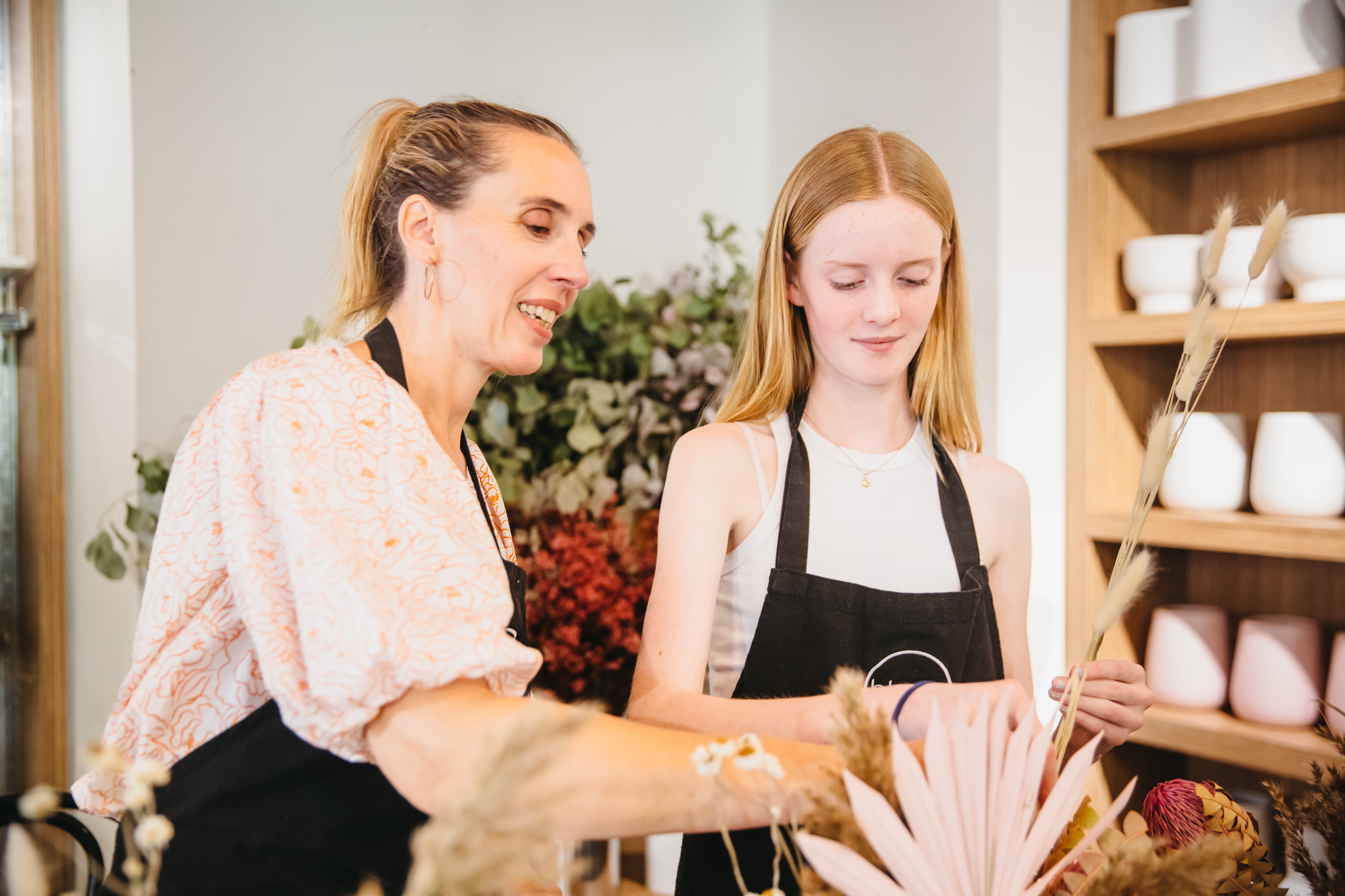 A mother and daughter arrange flowers together