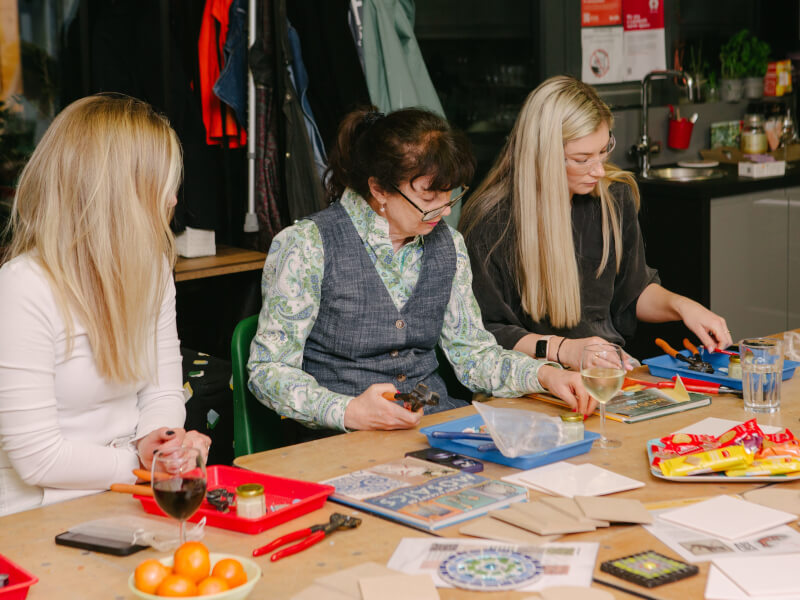 A mother at a mosaic class with her two daughters