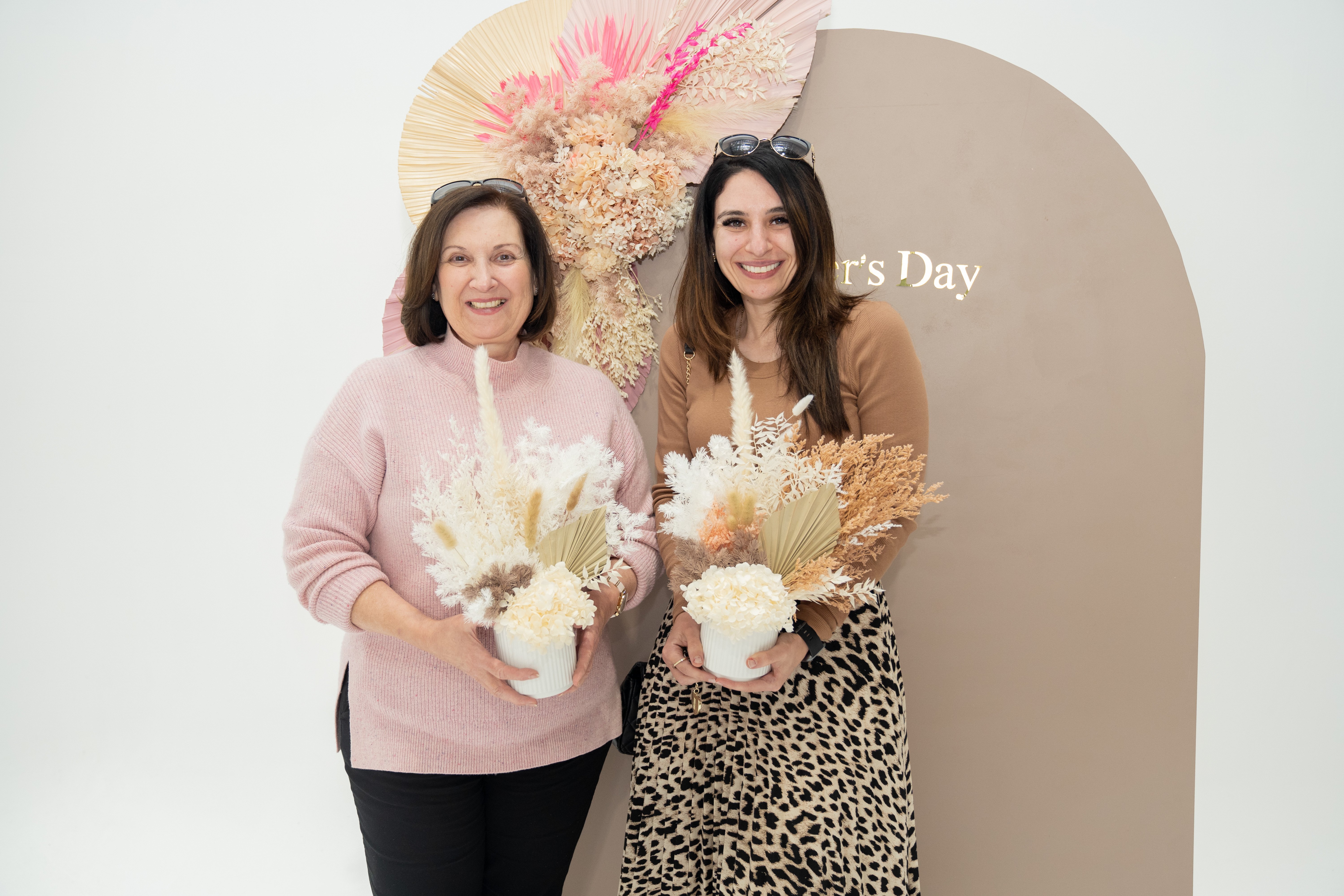 Mother and daughter holding their dried flower arrangements