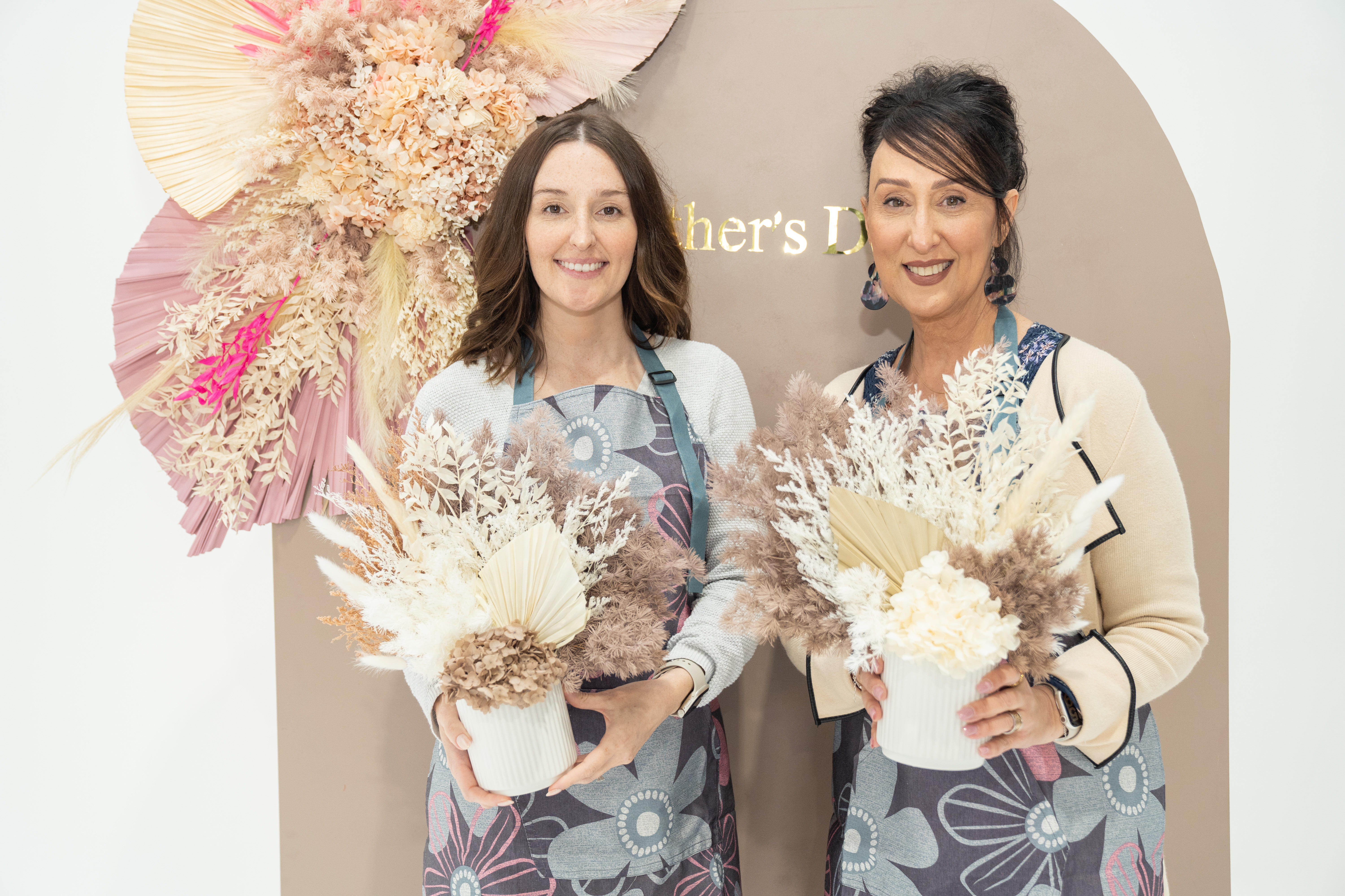Mother and daughter holding their dried flower arrangements