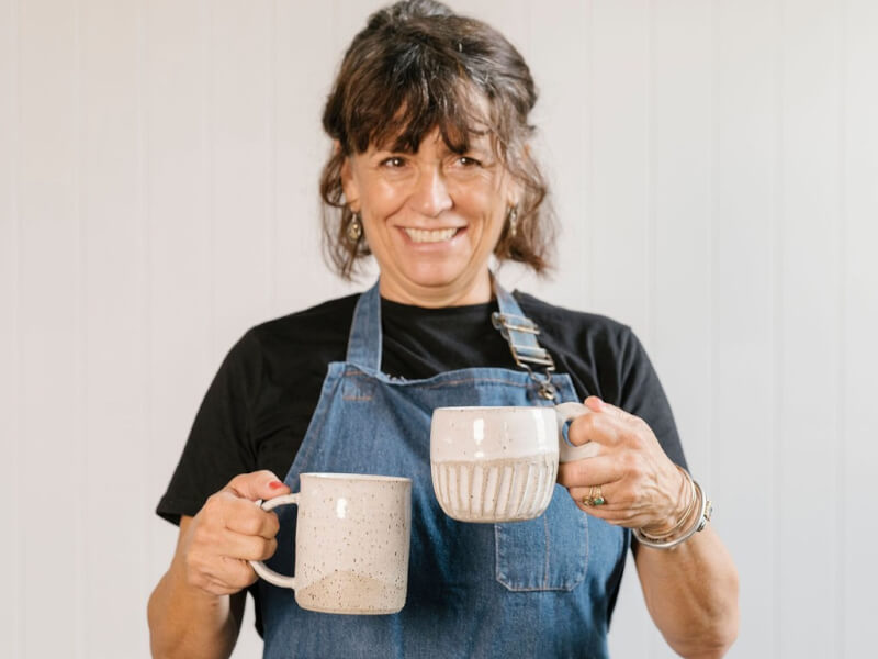 A woman holding a set of coffee cups