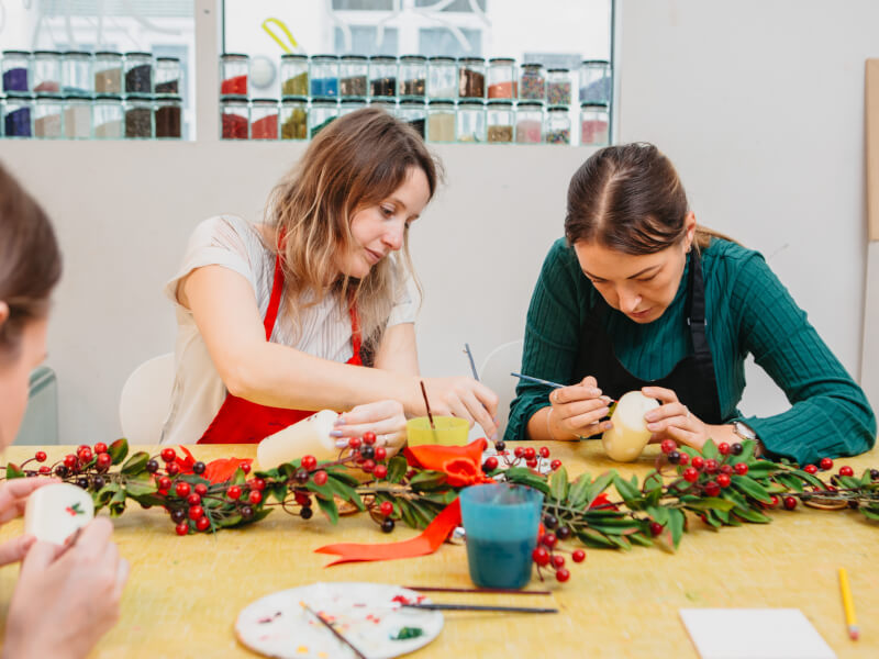 Mother and daughter painting candles at a candle workshop