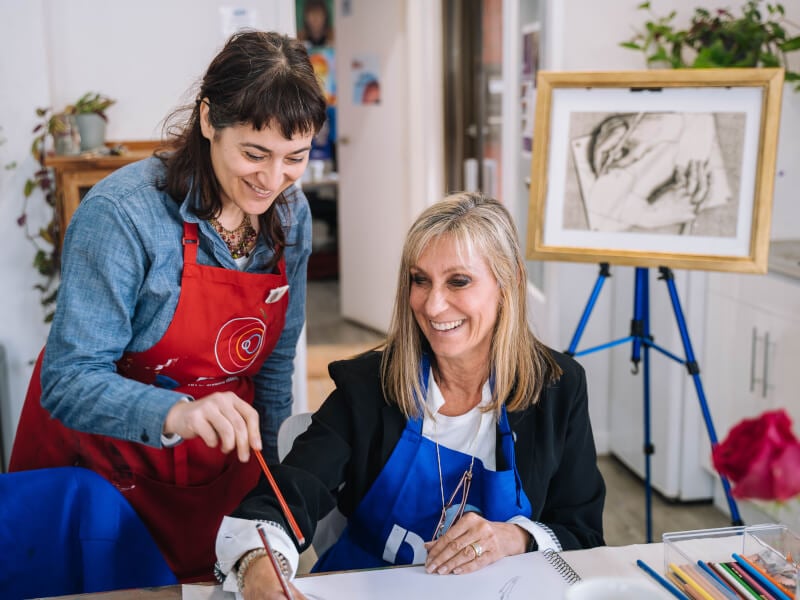 Woman smiling with teacher at art class