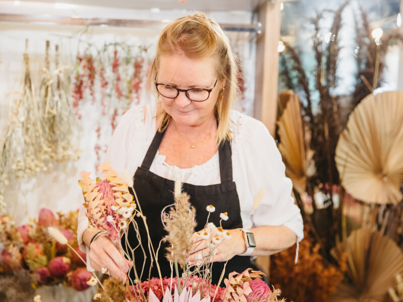 A mother arranging flowers at a class for her birthday