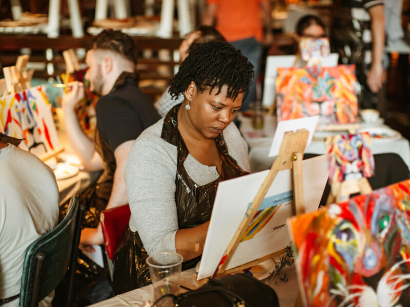 A woman enjoying a Mother's Day paint and sip