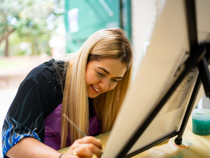 A woman painting at a paint and sip class she was gifted