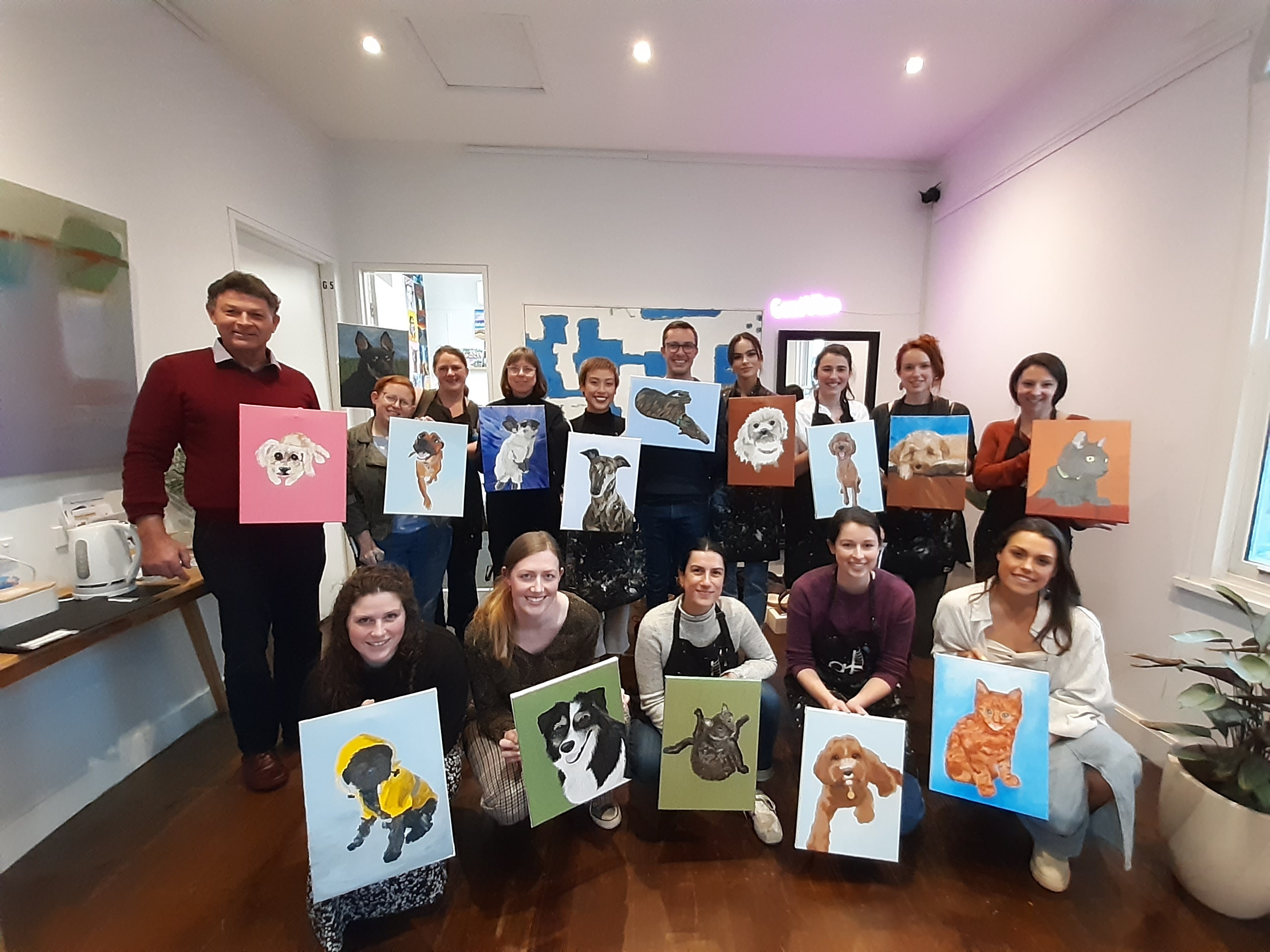 People showing their pet paintings