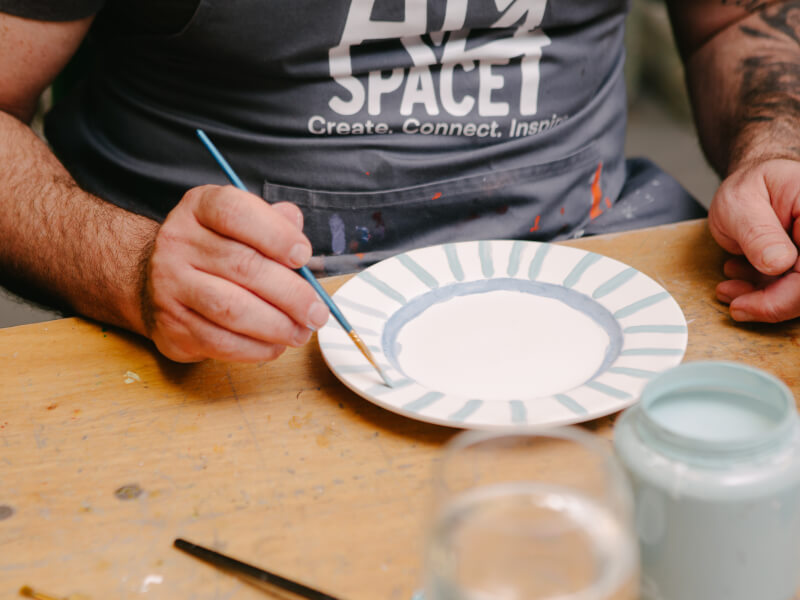 A man painting a plate
